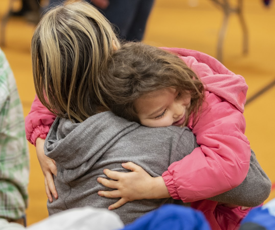 Happy child hugging volunteer Operation warm event